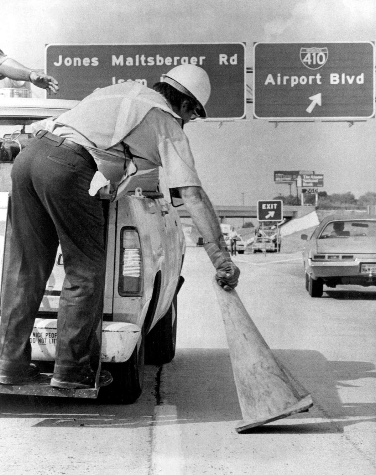 An employee of the state highway department picks up the last traffic cone to open McAllister Freeway, from downtown to San Antonio International Airport, in 1978. The freeway, also called U.S. 281 North, was extended to Loop 1604, and has been a major growth corridor for the city.