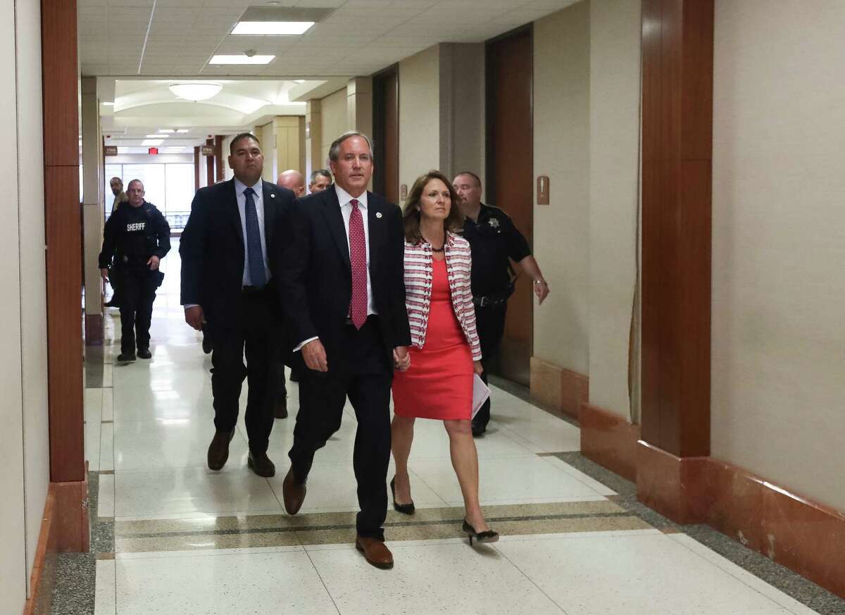 Texas Attorney General Ken Paxton, center front, and his wife Angela Paxton, right, enter the 177th District Court at the Harris County Criminal Justice Center, Thursday, June 29, 2017, in Houston.