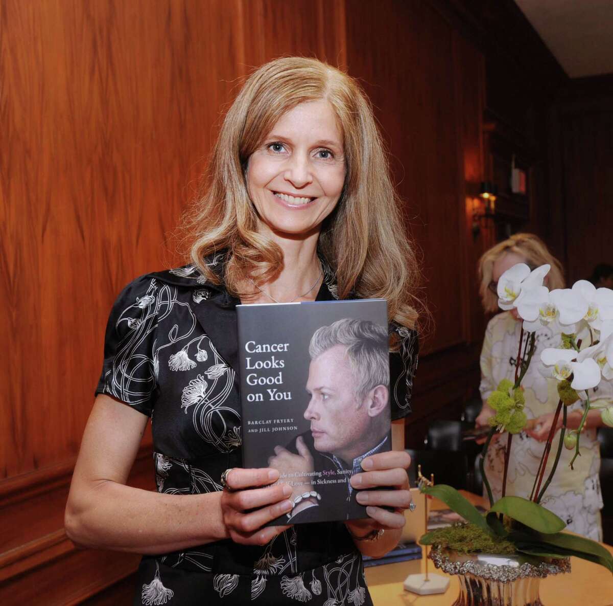 Jill Johnson holds the book “Cancer Looks Good on You,” that she co-wrote with the late Greenwich resident Barclay Fryery, a renowned interior designer, during a life celebration for Fryery and book launch event at the Greenwich Arts Council, Greenwich, Conn., Thursday night, June 29, 2017. Fryery died recently.
