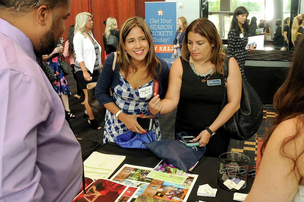 Marissa Burres and Francis Perdomo browse for information Friday at the Hispanic Chamber of Commerce's annual Women's Leadership Conference and Business Expo.﻿