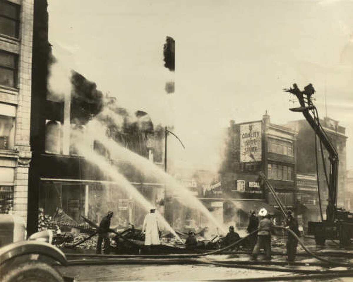 A civilian bucket truck, on the right, was commandeered by the fire department to fight a fire in the mid to late 1930s.