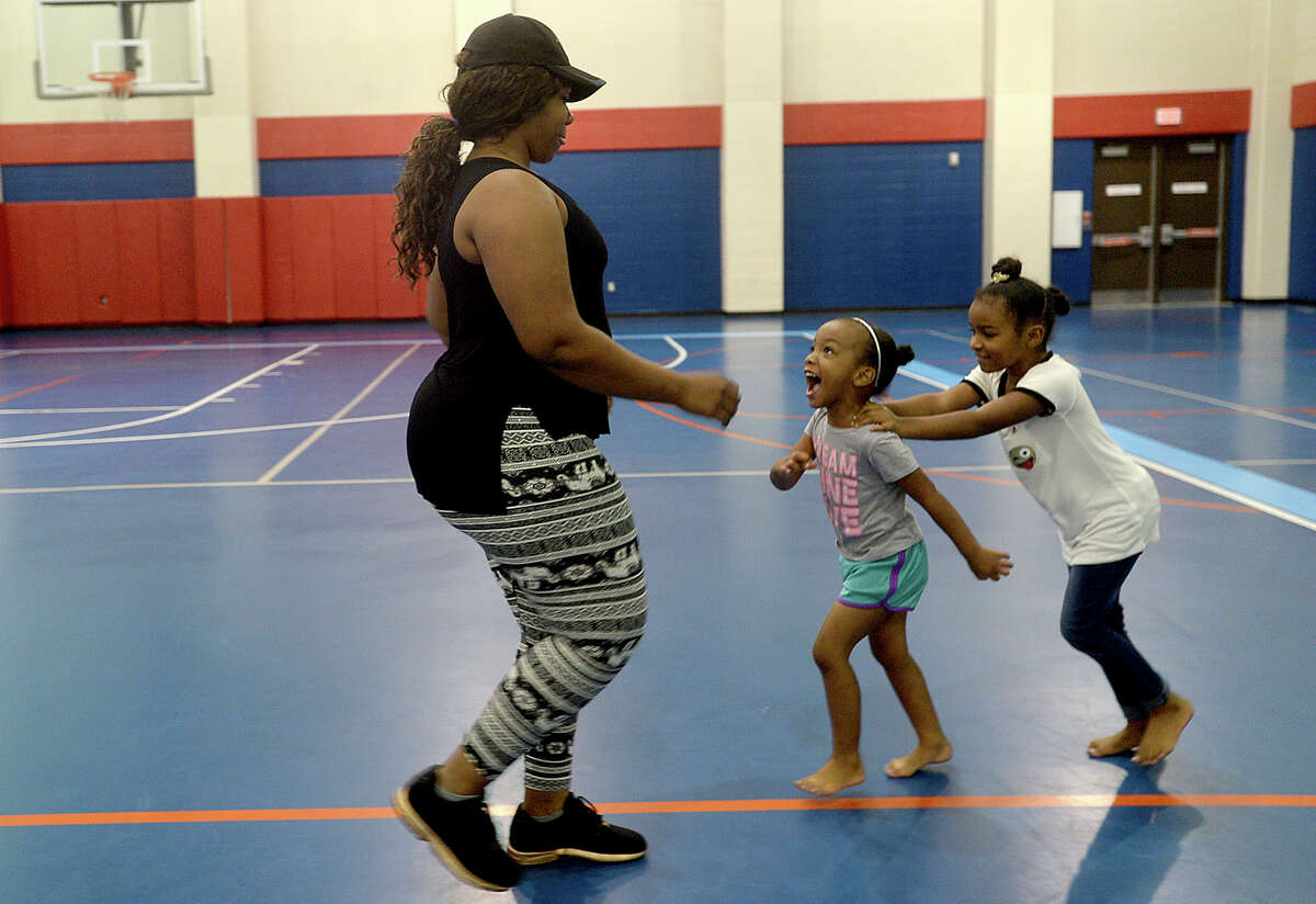 Sisters Jasmine and Zoe Sims chase after their mother Latoya Burkes as she joins in the routine during the Zumba by Jentonic class held Thursday at the Sterling Pruitt Activity Center. Instructor Jennafer Hamilton offers free Zumba classes Tuesday and Thursdays at 6:15, and paid sessions, which are $2 per class, Mondays and Wednesdays at 7:15. Photo taken Thursday, June 29, 2017 Kim Brent/The Enterprise