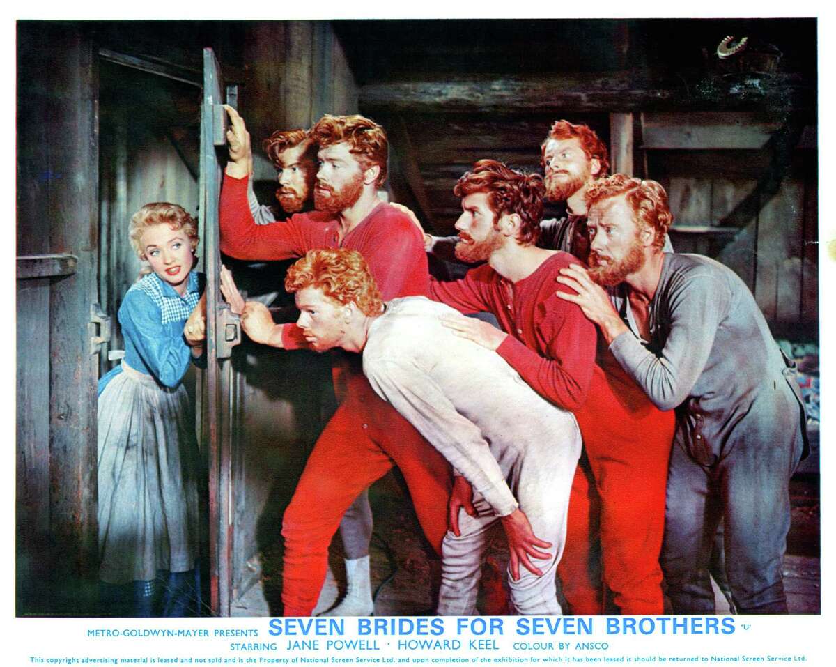 Jane Powell opens a door to find Jeff Richards, Russ Tamblyn and the rest of the brothers in a scene from the film “Seven Brides For Seven Brothers” (1954).