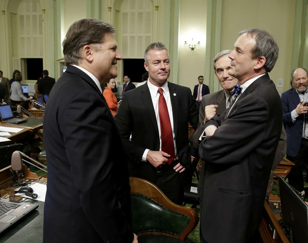 FILE - In this Dec. 1, 2014 file photo, California state Sen. Bob Hertzberg, D-Van Nuys, left, talks with Charles Munger, Jr., right, as Assemblyman Travis Allen, R-Huntington Beach, second from left, and former Republican lawmaker Phil Wyman listen at the Capitol in Sacramento, Calif. Allen said Thursday, June 22, 2017, he's entering the 2018 California gubernatorial race that has largely been dominated by Democrats. (AP Photo/Rich Pedroncelli, file)