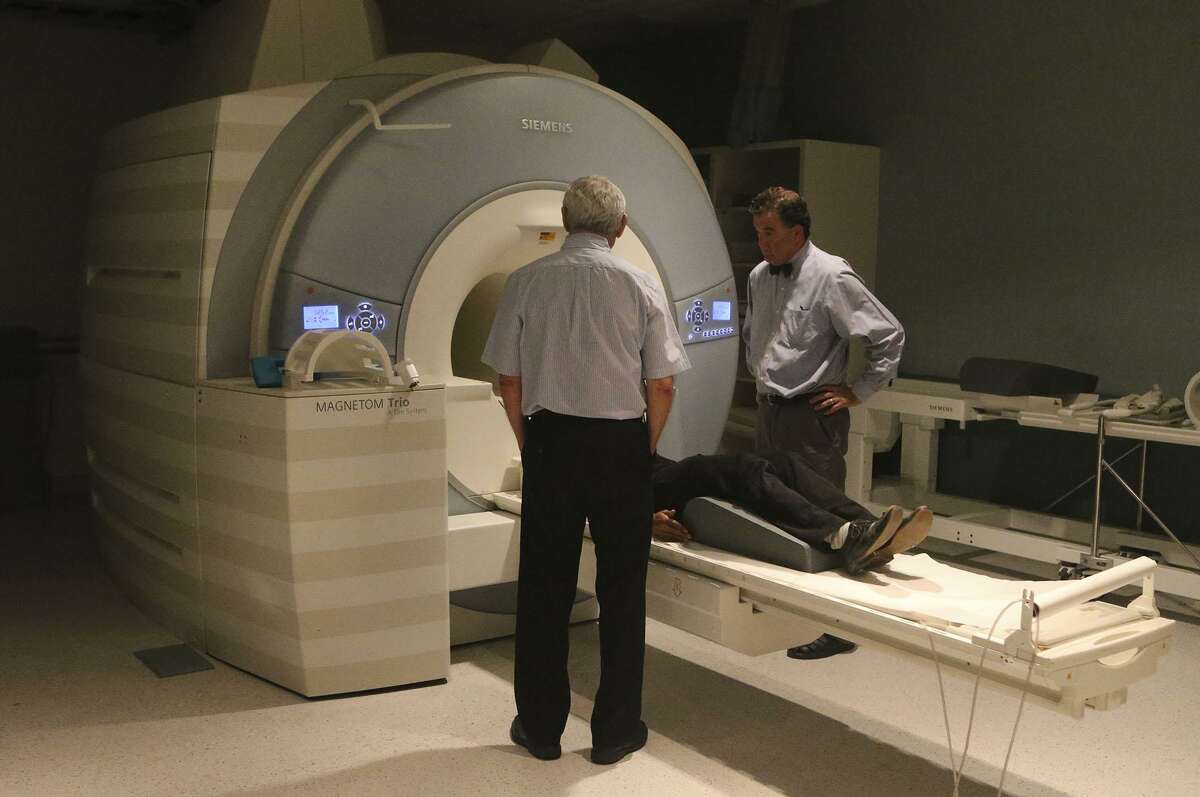 Doctor Peter Fox (right) stands with physicist Jack Lancaster (left) by a magnetic resonance imager at the Univerity of Texas Health Science Center's Greehey Academic and Research Campus. Fox is involved in a study that will test the use of magnetic current to treat depression.