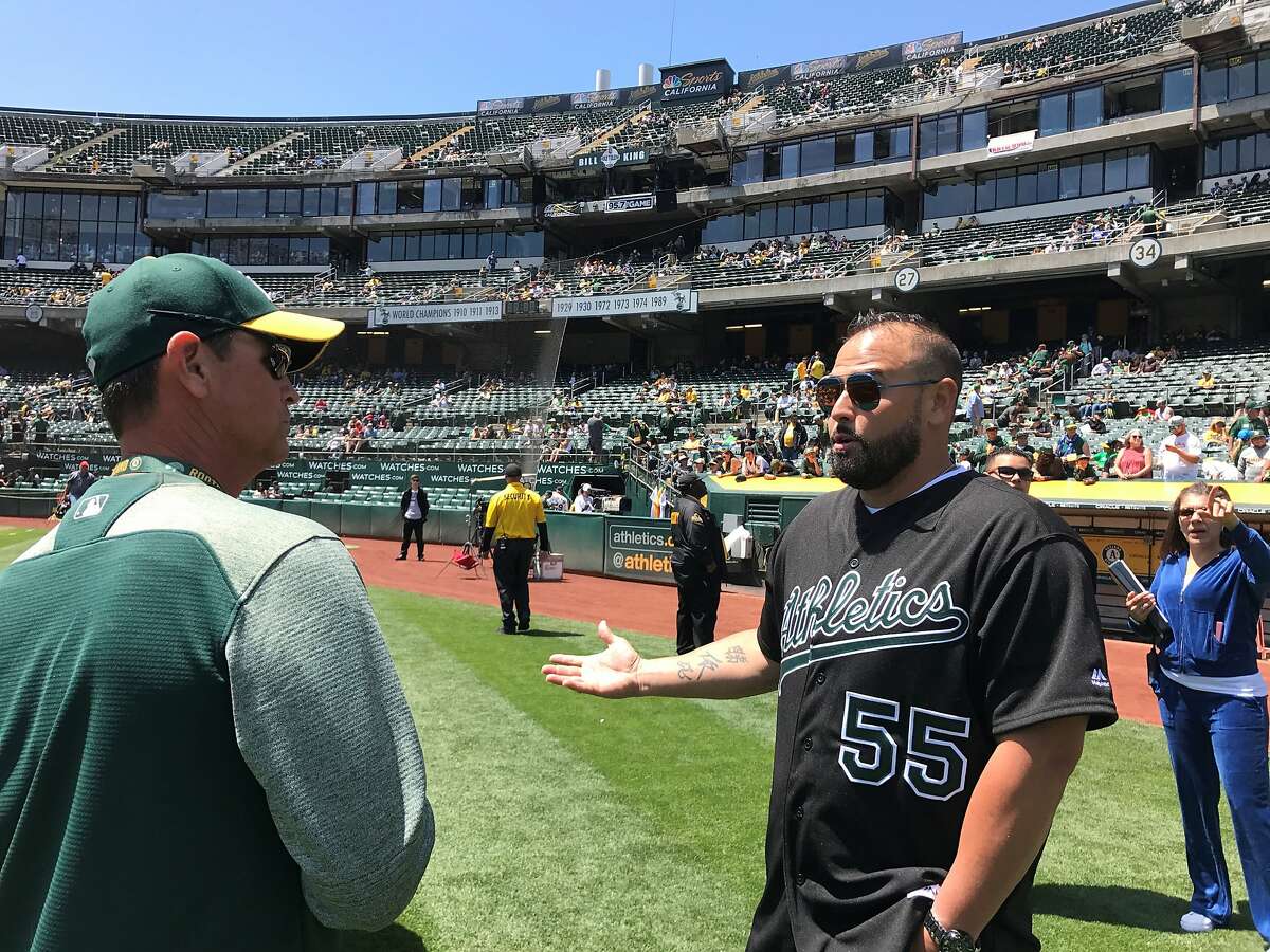 Former A's catcher Ramon Hernandez, left, catches up with head grounds keeper Clay Wood before Saturday's game.