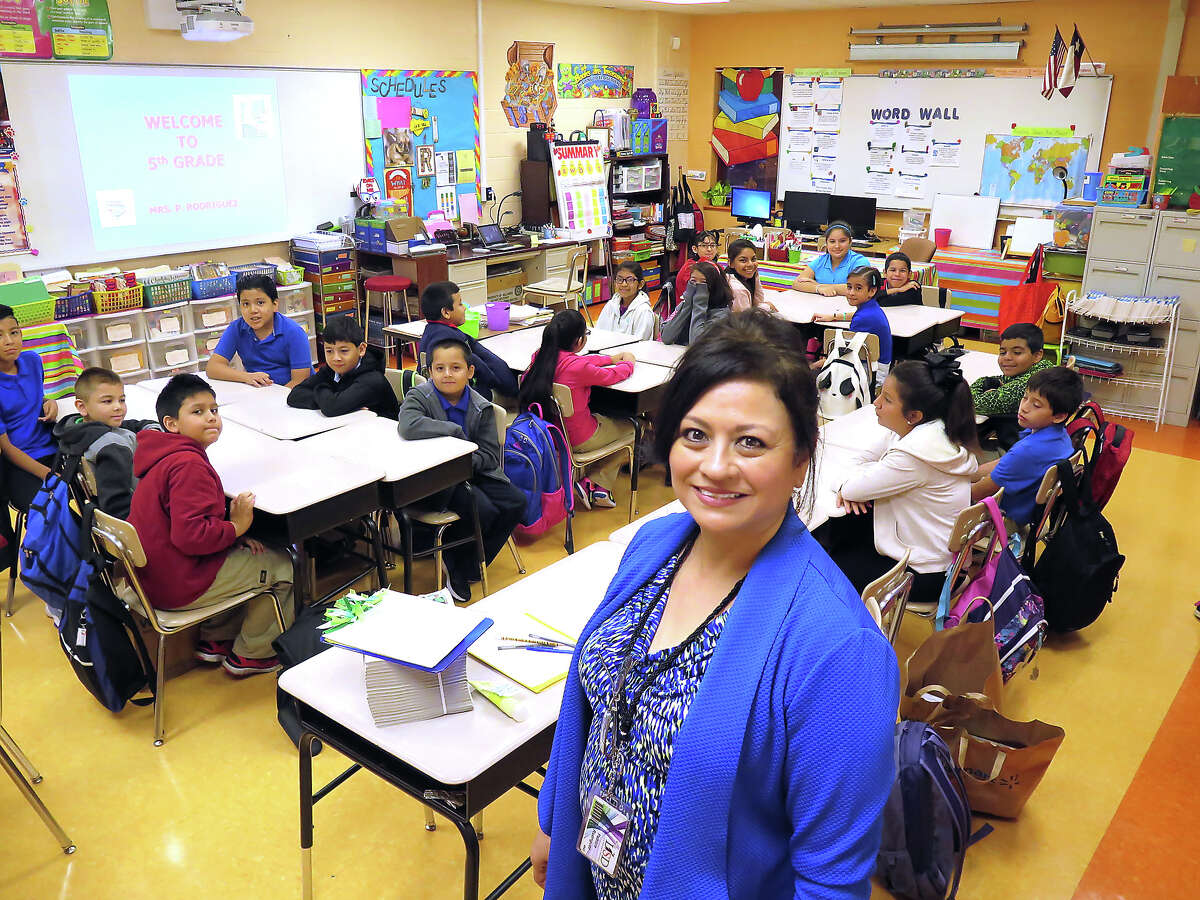 Bruni Elementary 5th grade teacher Patricia Rodriguez poses with her students Monday morning as they start the new school year.