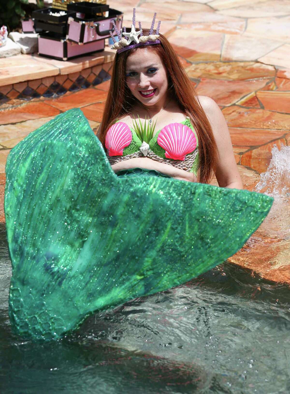Mirella Aram, known as Mermaid Ella, flips her big tail to make splashes by the pool Saturday, July 1, 2017, in Pearland. 