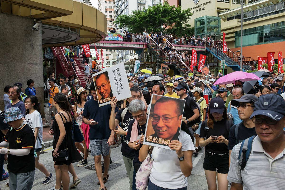 Protesters hold pictures of activist Liu Xiaobo as they march on July 1 during a demonstration in Hong Kong.