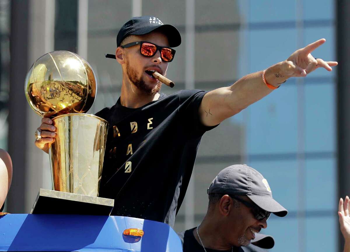 FILE - In this June 15, 2017, file photo, Golden State Warriors' Stephen Curry waves at fans during a parade and rally in Oakland, Calif., celebrating the team's the NBA basketball championship. One of the NBA's biggest bargains until now, Curry is about to receive his massive payday. Golden State general manager Bob Myers said Friday, June 30, 2017, the Warriors will finalize a contract with the two-time MVP once the free agency moratorium ends July 6. (AP Photo/Marcio Jose Sanchez, File) ORG XMIT: NY164