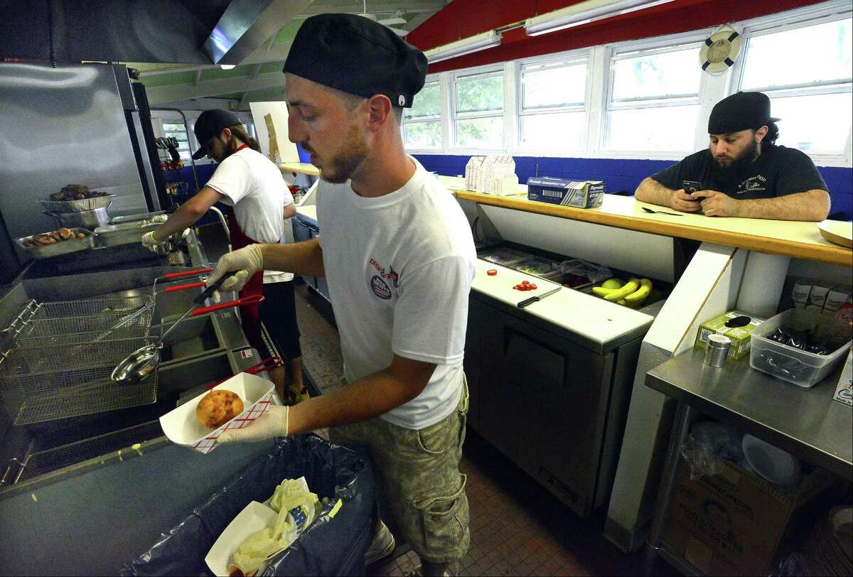 Tyler Burchard, manager of Drop & Fry, pulls an order of Fried Ice Cream from the fryer he was preparing for a customer of the new concession at Cummings Beach in Stamford, Conn., on Friday, June 23, 2017.