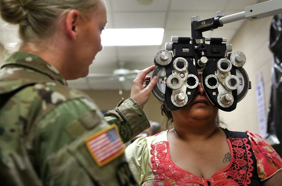 Irma Sanchez, 38, of Laredo, has her eyes checked by Maj. Jennifer Meadows on Tuesday in a mobile clinic set up in the El Cenizo Community Center in El Cenizo, Texas. The Army and students from Texas A&M have been working together on health care training.