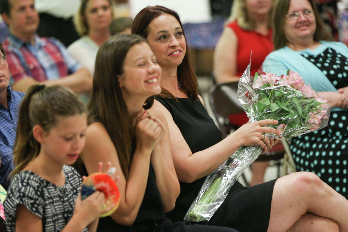 Amanda Bridges receives flowers and smiles as her children laugh during the retirement ceremony for Air Force Lt. Col. Robert Todd Bridges on Saturday, July 1, 2017, at Conroe VFW Post 4709.
