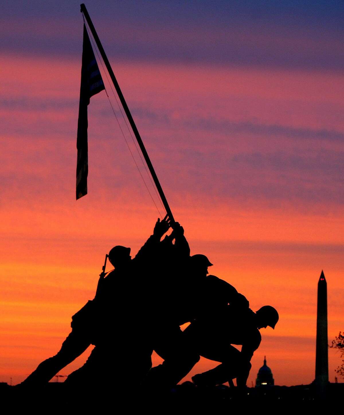 The sun rises behind the Iwo Jima Memorial in this May 5, 2003, file photo.