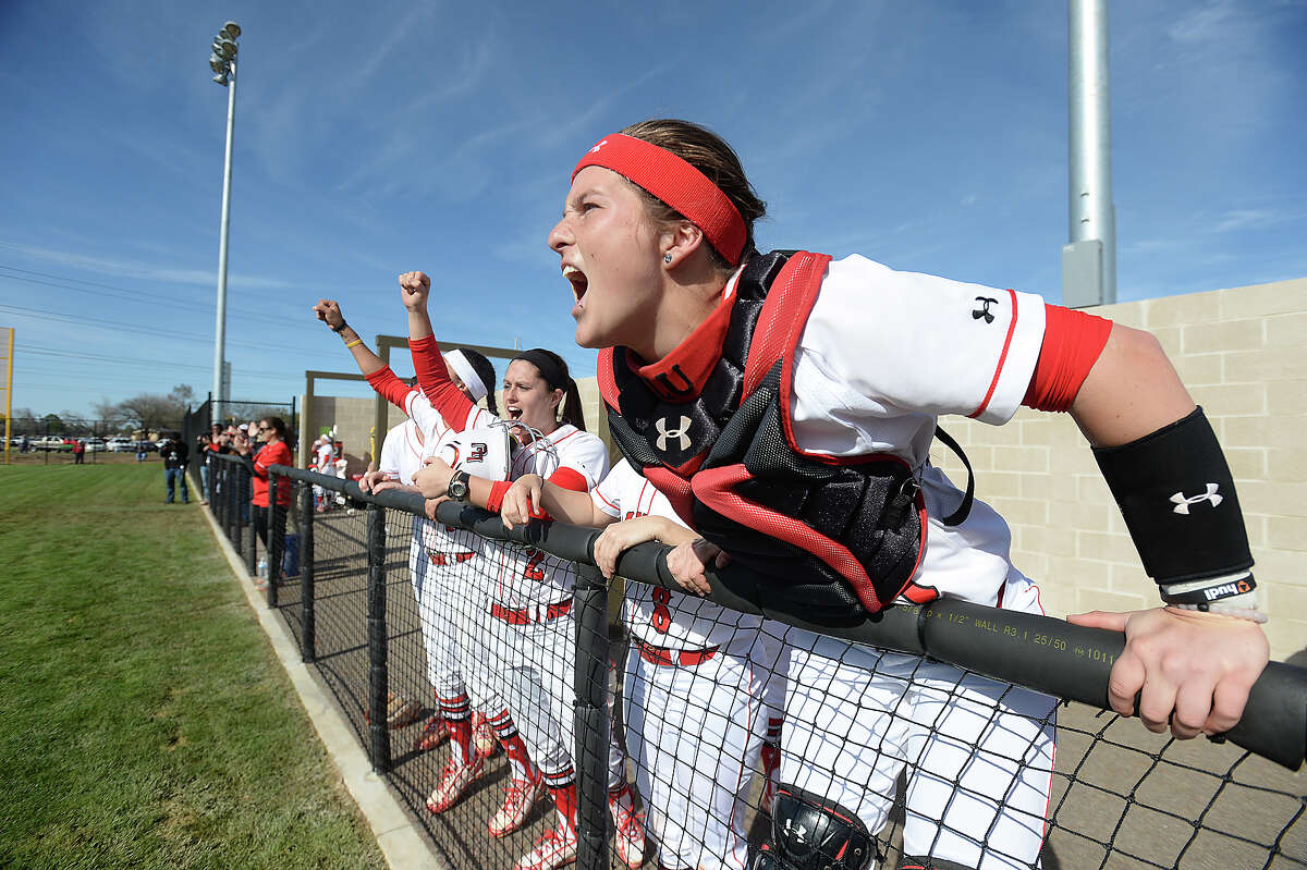 The Lady Cardinals, including catcher Brynn Baca, cheer from the dugout as they add points to the scoreboard on the grand opening of their new home field Friday. Lamar faced Houston Baptist on their new home turf for the first of a double-header. Photo taken Thursday, March 5, 2015 Kim Brent/The Enterprise