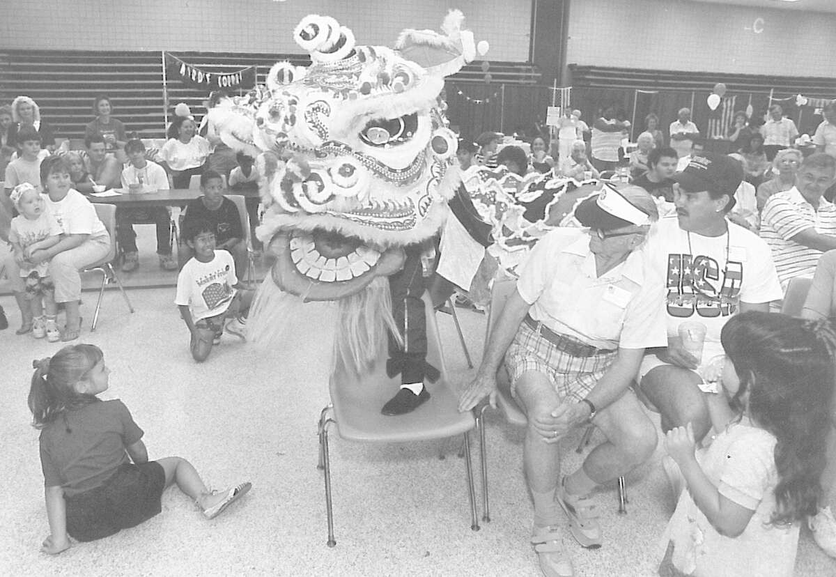 Dragon dancers from the Buu Mon Buddhist Temple of Port Arthur weave their way through the audience at the Port Arthur Civic Center. Phot taken July 4, 1991.