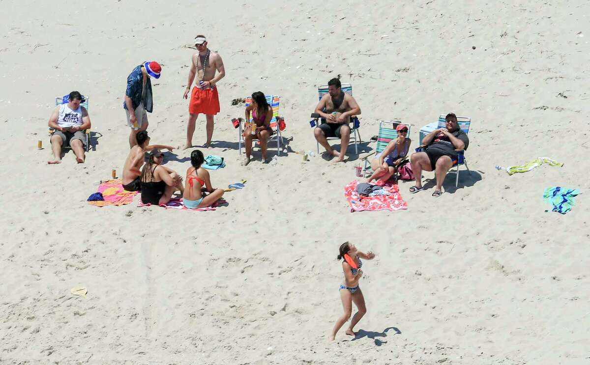 New Jersey Gov. Chris Christie, right, relaxes at Island Beach State Park on Sunday with family and friends. Christie defended his visit, saying he had announced his vacation plans before the government shutdown.