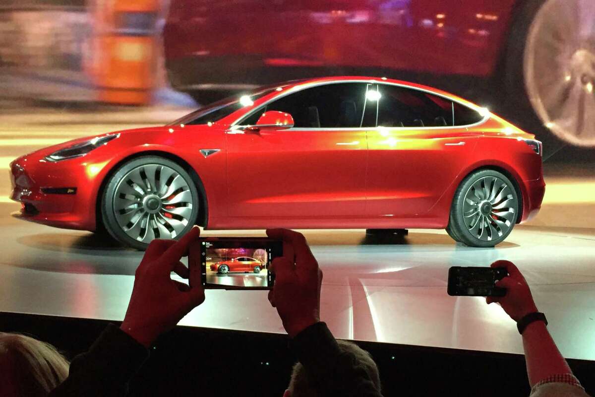 In this March 31, 2016, file photo, Tesla Motors unveils the new lower-priced Model 3 sedan at the Tesla Motors design studio in Hawthorne, Calif. Electric car maker Tesla said on Monday, July 3, 2017, that its Model 3 car will go on sale on Friday. (AP Photo/Justin Pritchard, File)