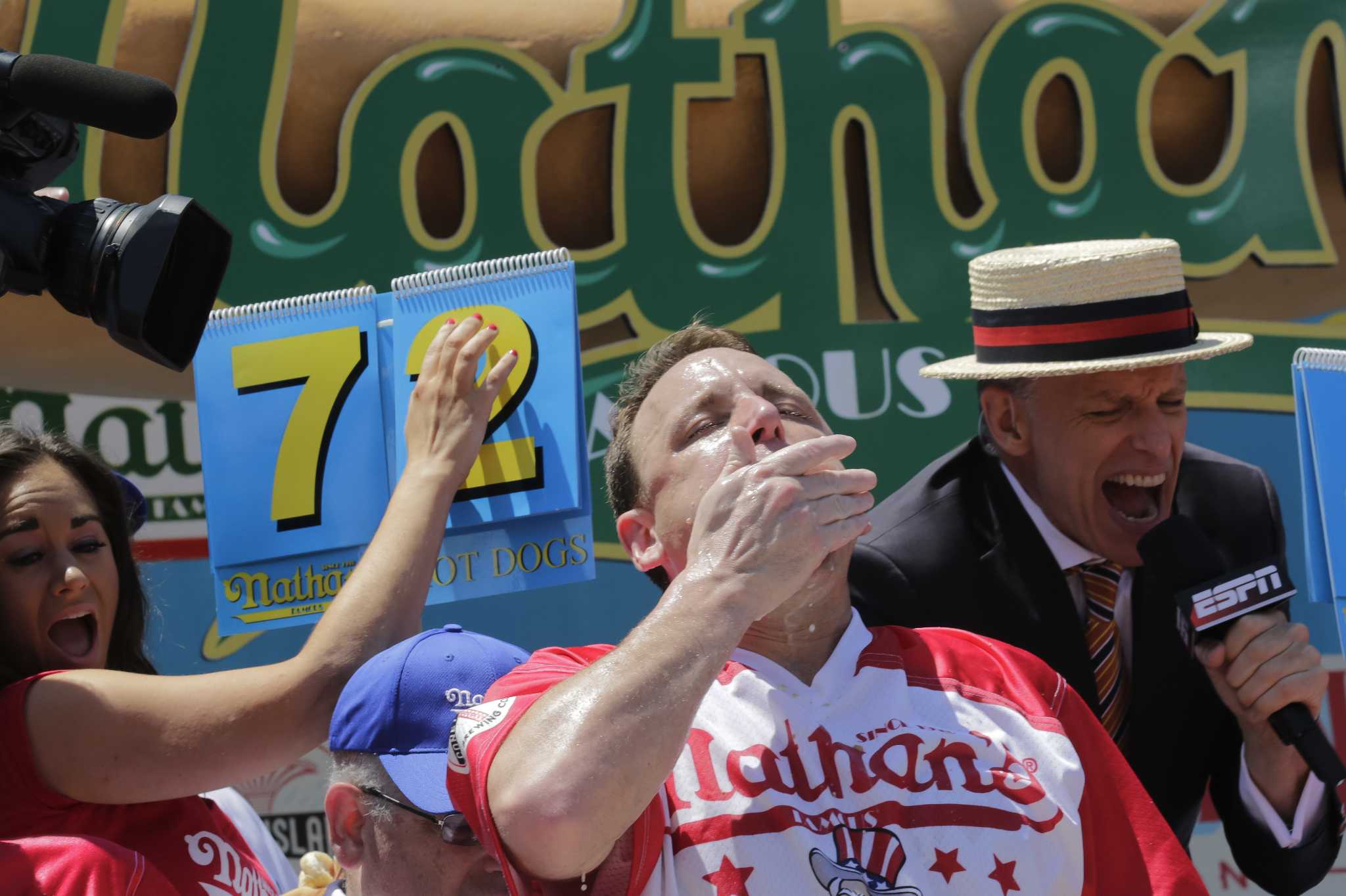 Champion hot dog eater sets record, keeps title
