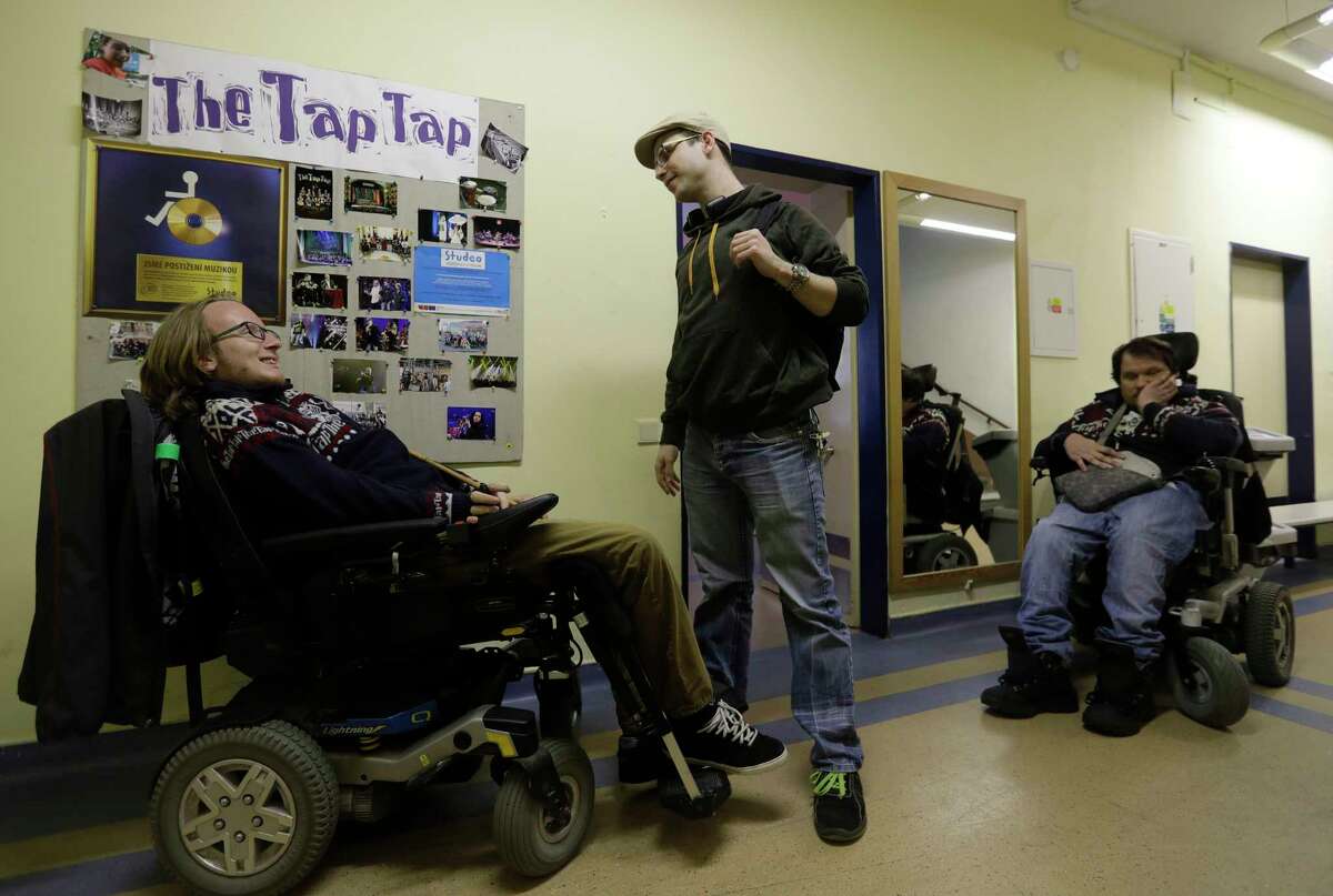 In this picture taken on Tuesday, May 2, 2017, members of the Tap Tap orchestra wait for the start of their rehearsal in front of their studio in Prague, Czech Republic. What was created some 18 years ago in efforts to give kids some extracurricular activity at a renowned school for the disabled in Prague has become a major music act that has drawn millions of listeners and fans, first at home and gradually abroad. (AP Photo/Petr David Josek)