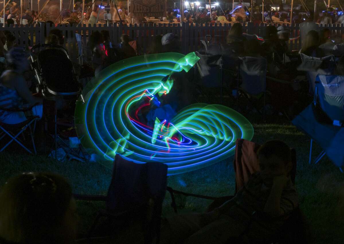 Children and adults dance and swing glow sticks 7/04/17at the Star-Spangles Salute at Hogan Park. Tim Fischer/Reporter-Telegram
