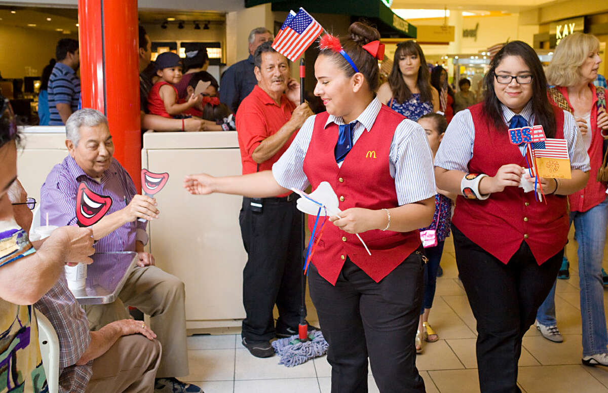 McDonald's employees handing out smiling props during a children's 4th of July parade hosted by the Imaginarium of South Texas at Mall Del Norte on Tuesday afternoon.