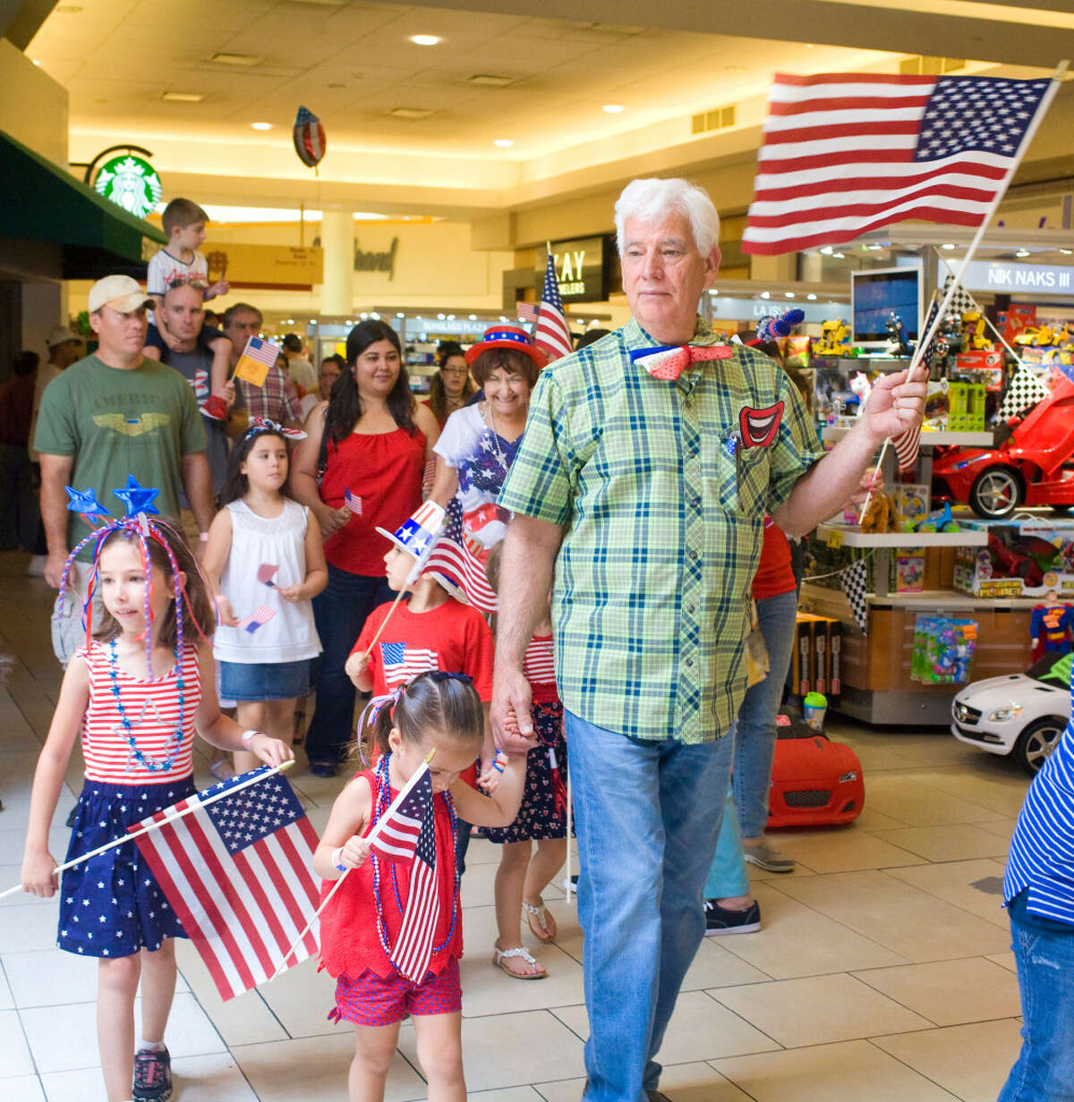 Local families dressed in patriotic attire march their way through a children's 4th of July parade hosted by the Imaginarium of South Texas at Mall Del Norte on Tuesday afternoon.