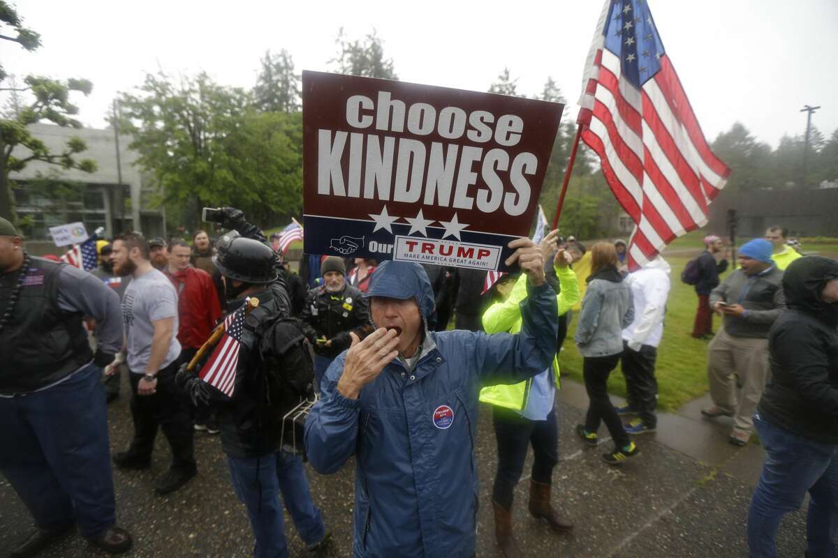 A member of the conservative group Patriot Prayer mocks a yawn as he turns his back to counter-protesters, Thursday, June 15, 2017, at The Evergreen State College in Olympia, Wash. (AP Photo/Ted S. Warren)