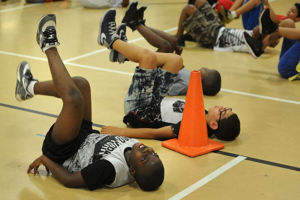 Klein Pasture, left, and his fourth grade classmates do bicycle kicks as part of a stretching routine during gym class in the Lighthouse summer program at Luis Munoz Marin School in Bridgeport, Conn. on Wednesday, July 5, 2017. The city Board of Education narrowly approved the program, a fixture in city schools since it's founding in 1993.