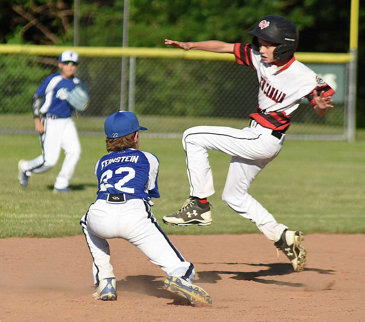 New Canaan baserunner Jack Sommers, right, goes airborne to try and avoid the tag of Norwalk's Henry Feinstein on a stolen base attempt during Wednesday's District 1 Cal Ripken 11-year-old All-Stars championship game at Tim Devine Field in Norwalk. Sommers was out on the play and Norwalk went on to post a 10-0 win.