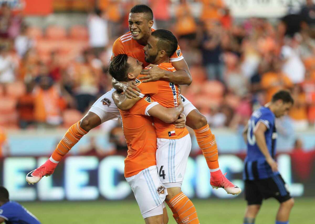 Mauro Manotas, top, and Erick Torres, left, help Alex celebrate his first-half goal.