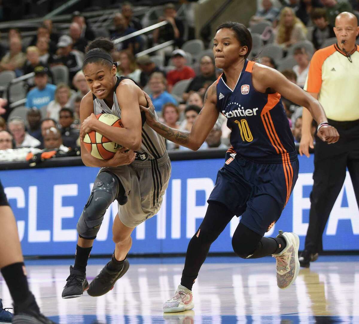 Moriah Jefferson of the San Antonio Stars protects the ball as she drives into the lane during WNBA action against the Connecticut Sun at the AT&T Center on Wednesday, July 5, 2017. Courtney Williams of the Sun gives chase.