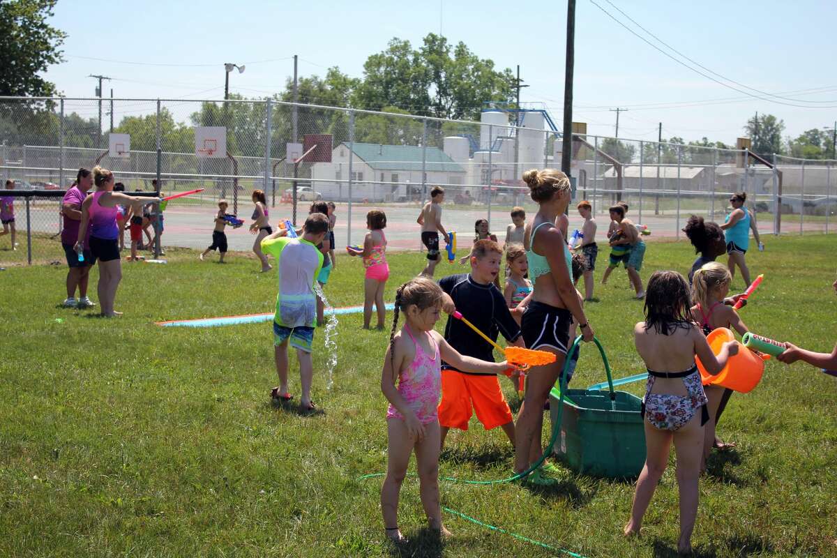 Kids in the Bad Axe Parks and Recreation program engage in a water fight in the scorching heat early Thursday afternoon.