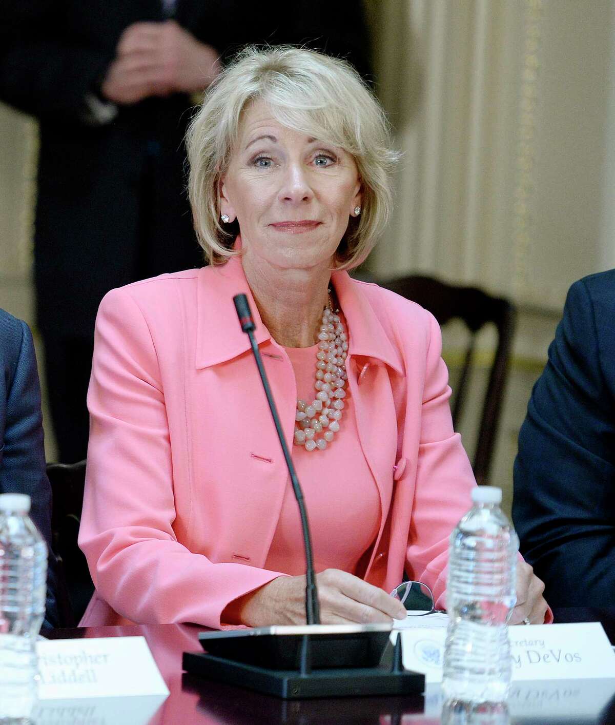 Education Sec. Betsy DeVos listens as U.S. President Donald Trump speaks during a strategic and policy discussion with CEOs in the State Department Library in the Eisenhower Executive Office Building on Tuesday, April 11, 2017 in Washington, D.C. DeVos is being sued by eighteen states. (Olivier Douliery/Abaca Press/TNS)