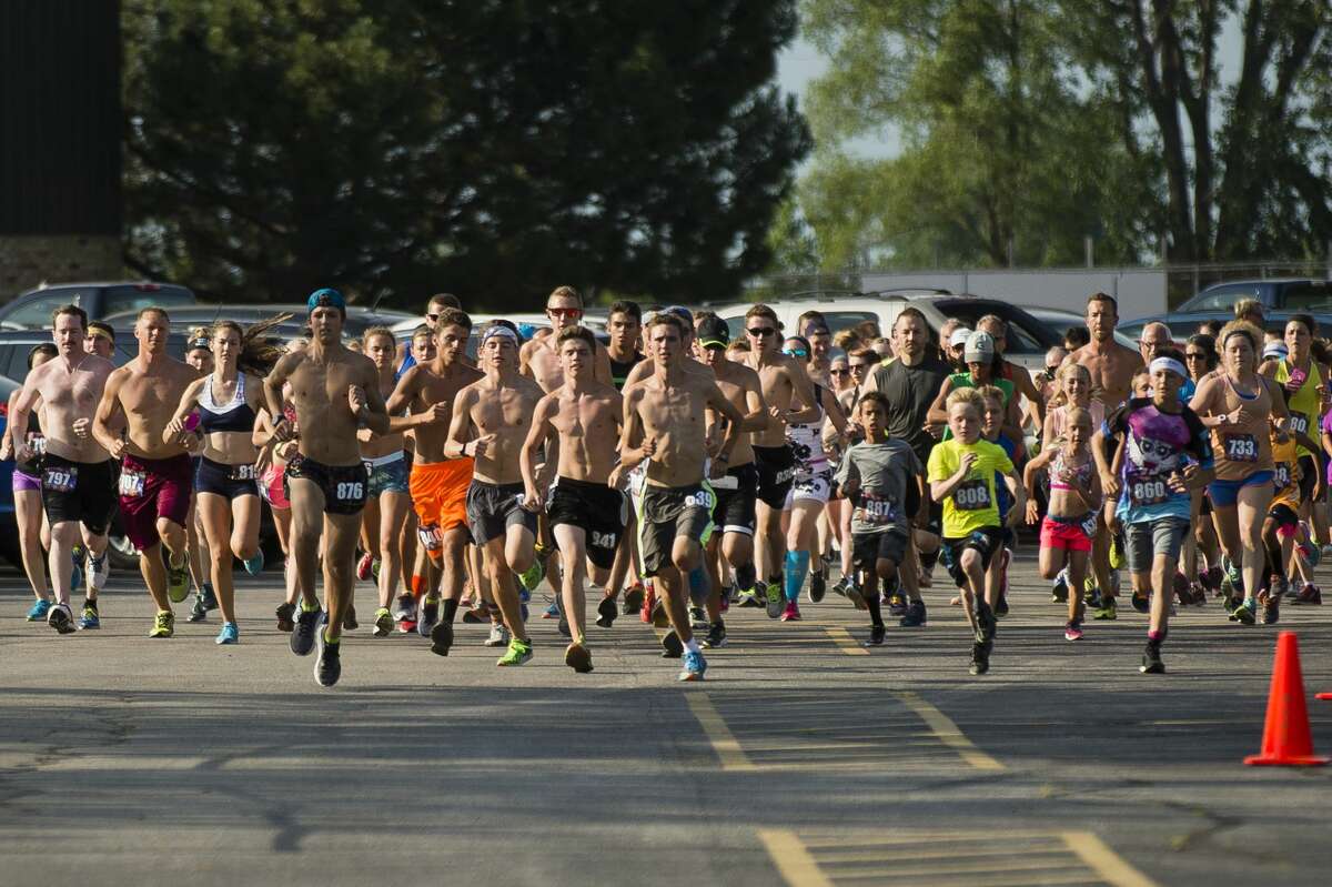 Runners take off at the starting line in the Auburn Cornfest 5K race on Thursday, July 6, 2017 in Auburn.