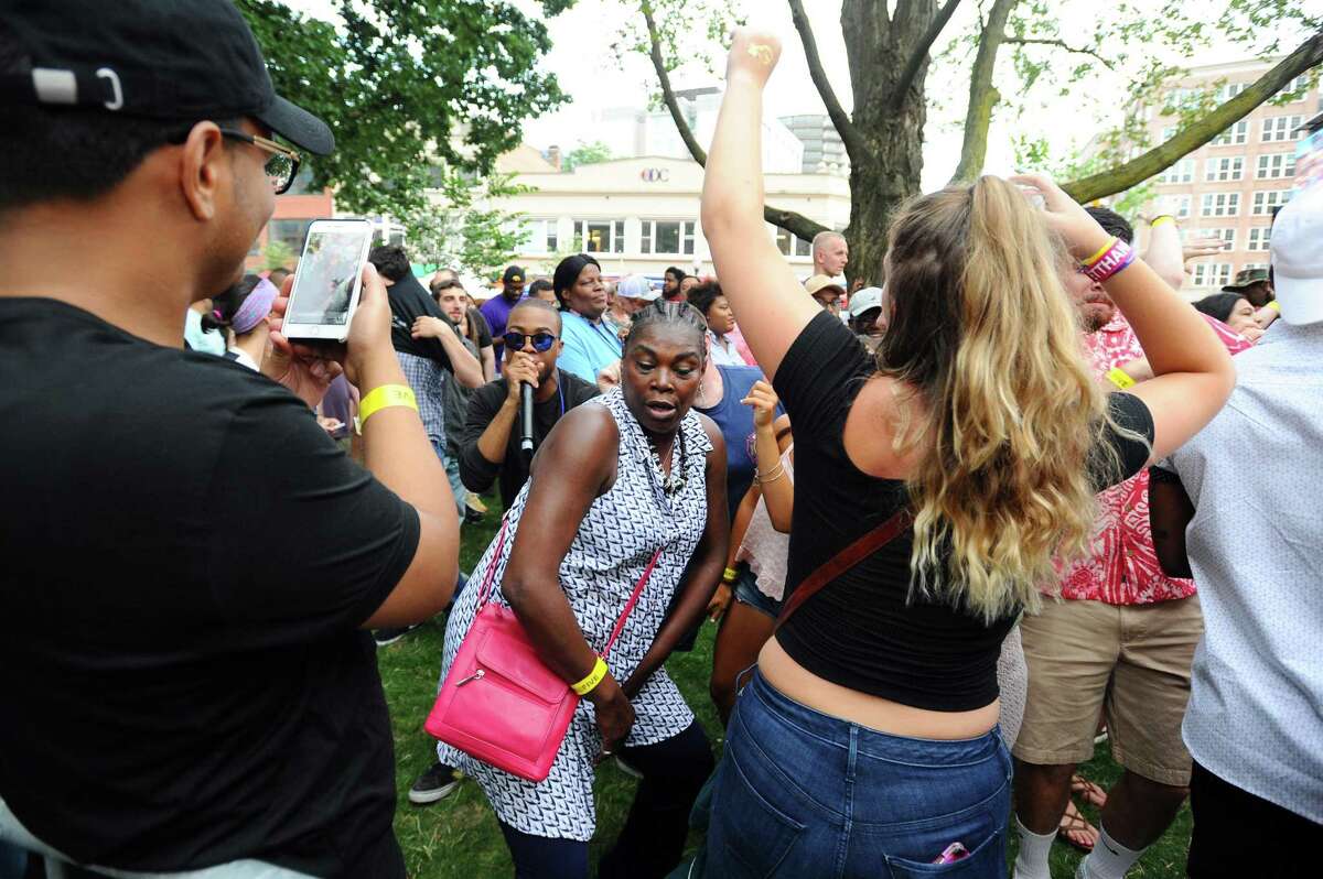Ramona Watts, on vacation in Stamford from Maryland, leads a group in dance during the first Alive@Five summer concert in Columbus Park in downtown Stamford, Conn. on Thursday, July 6, 2017.