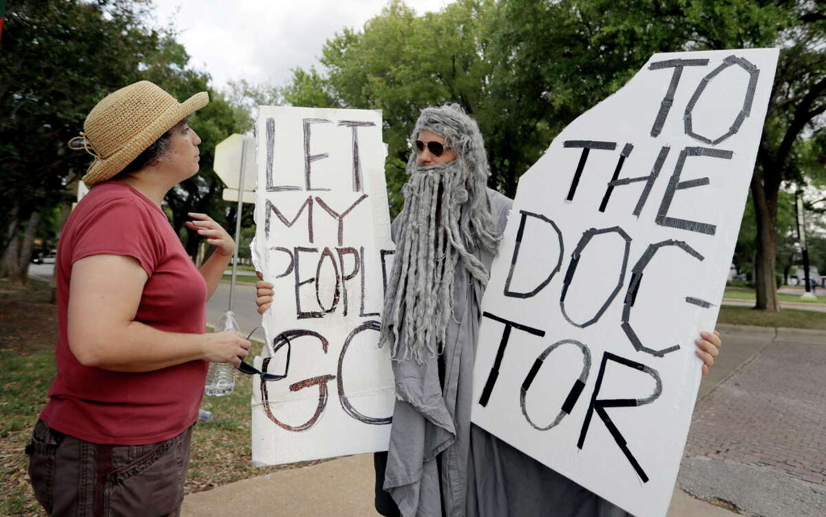John Erler, dressed as Moses, protests outside the site where Sen. Ted Cruz, R-Texas, held a town hall meeting, Thursday, July 6, 2017, in Austin, Texas. (AP Photo/Eric Gay)