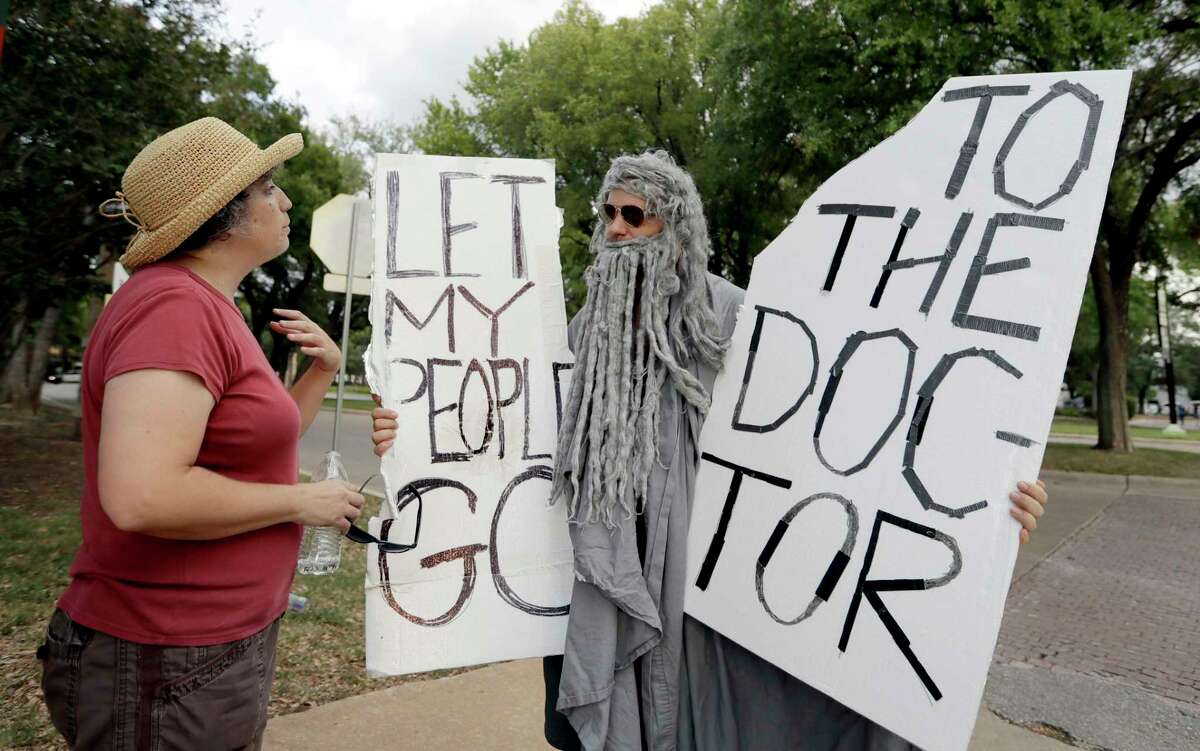John Erler protests outside the Austin site where U.S. Sen. Ted Cruz was holding a town hall.