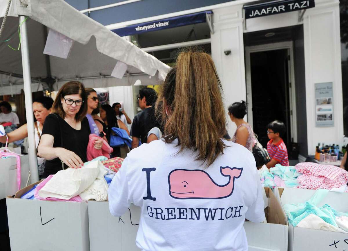 Vineyard Vines employee Morgan Blank, wears her company's trademark pink whale shirt, as she helps customers shopping outside the store during the annual Sidewalk Sales organized by the Greenwich Chamber of Commerce on Greenwich Avenue, Greenwich, Conn., Thursday, July 14, 2016. The 2017 event will be held Thursday, July 13, to Saturday, July 15, from 10 a.m. to 6 p.m. and Sunday, July 16, from 11 a.m. to 5 p.m.