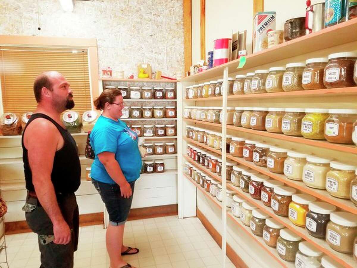   Stephanie Nelkie, right, and Jeff Nelkie, of Whittemore, observe the spice collection. They were first-time visitors to Country Corner Bulk Foods store on June 22.