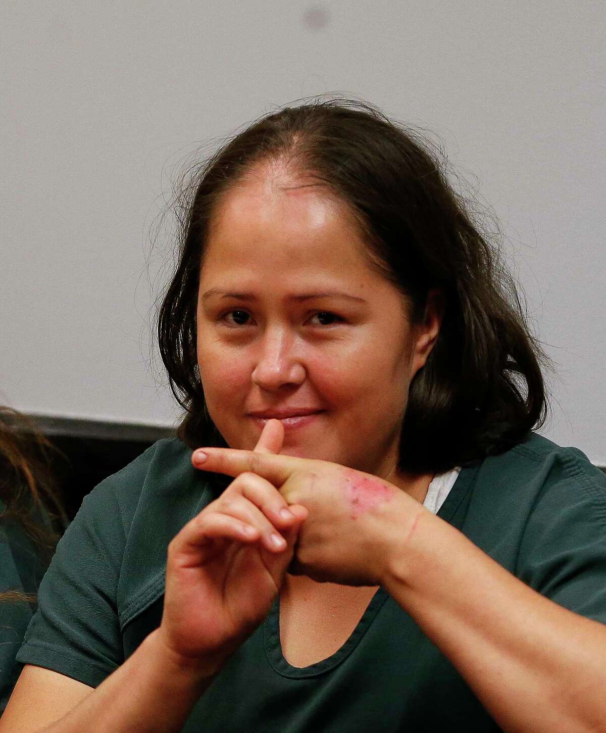 Isabel Martinez gestures towards news cameras during her first court appearance Friday, July 7, 2017, in Lawrenceville, Ga. Martinez is charged with killing four of her of children and their father. (AP Photo/John Bazemore)