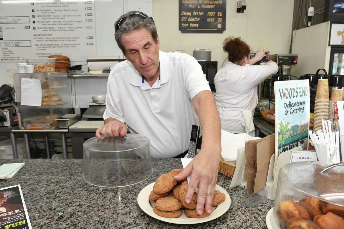 Fred Kaskowitz, owner of Woods End Deli in Bridgeport, adds more cookies to a display on the front counter.