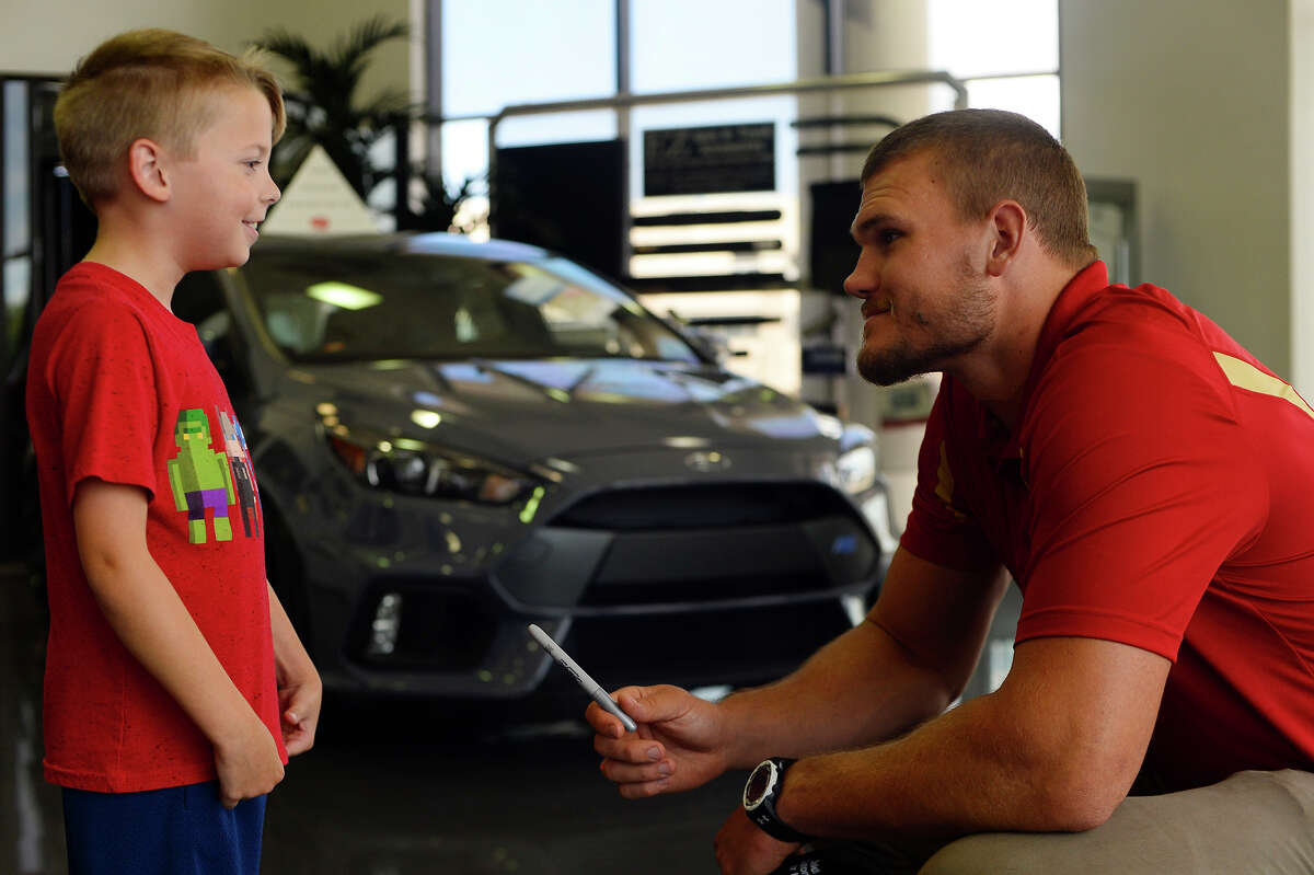 Nathan Oldbury, 8, talks with Vance McDonald, a Winnie native who plays tight end for the San Francisco 49ers, at Philpott Ford on Friday. Photo taken Friday 7/7/17 Ryan Pelham/The Enterprise