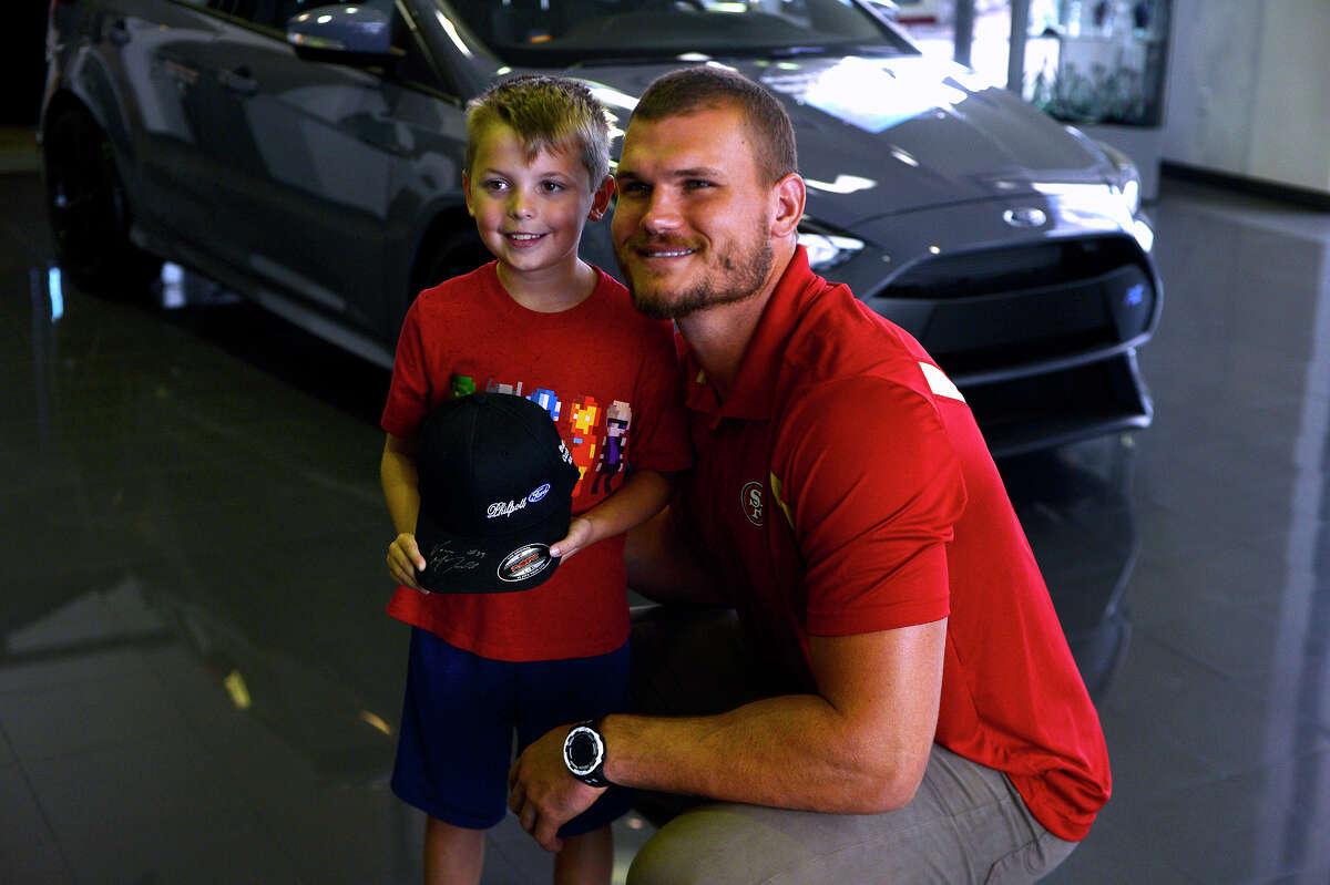 Nathan Oldbury, 8, with Vance McDonald, a Winnie native who plays tight end for the San Francisco 49ers, at Philpott Ford on Friday. Photo taken Friday 7/7/17 Ryan Pelham/The Enterprise