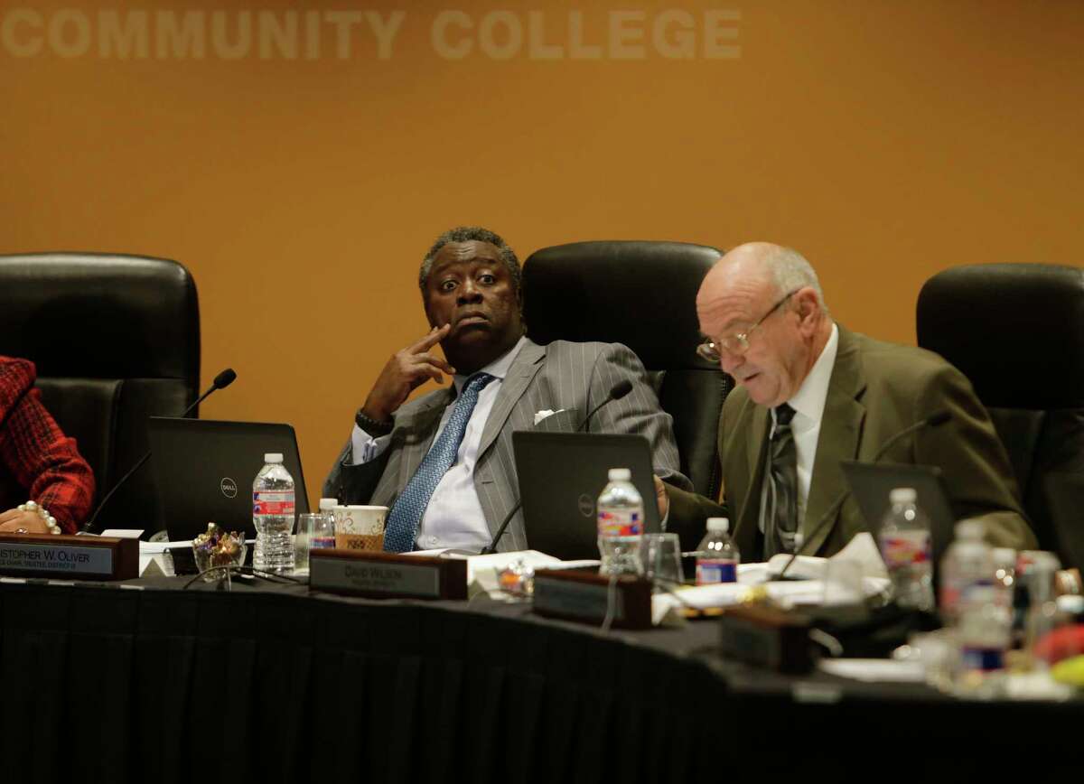 FILE - Houston Community College Board of Trustees member Christopher Oliver (left) participates in a board meeting in downtown Houston.
