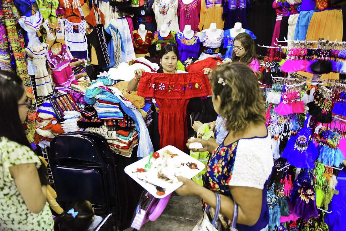 Janneth Guama muestra una blusa tradicional mexicana a clientes potenciales el viernes en Laredo Energy Arena durante el Festival Anual Ciudades Hermanas en su 15ava. edición.