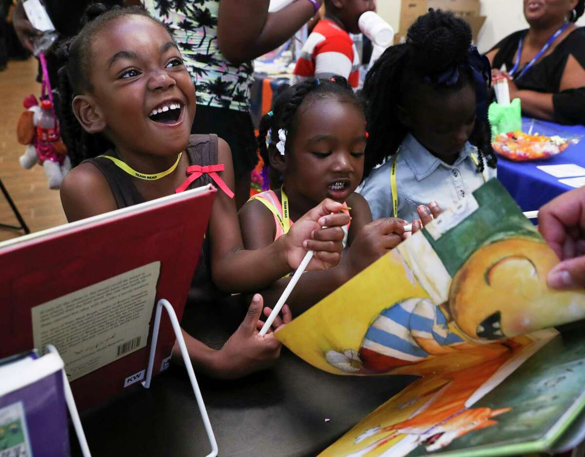 Jamiyah Credit, 4, left, and her cousin, Tyler Bogany, 3, react to the storyline of a child book that Harris County Public Library Programs and Outreach Specialist Anjela Martinez is reading at the Haverstock Hills Community Resource Fair Saturday, July 8, 2017, in Houston. Although Jamiyah and Tyler do not live in the neighborhood, but they come here all the time to be babysitted by their grandmother, Marilyn Bogany, who is a resident of the community. Harris County District Attorney Kim Ogg, Harris County Sheriff Ed Gonzalez, the Office of Harris County Judge Ed Emmett and the management of the Haverstock Hill Apartments hosted the fair to reach out to the community residents. ( Yi-Chin Lee / Houston Chronicle )