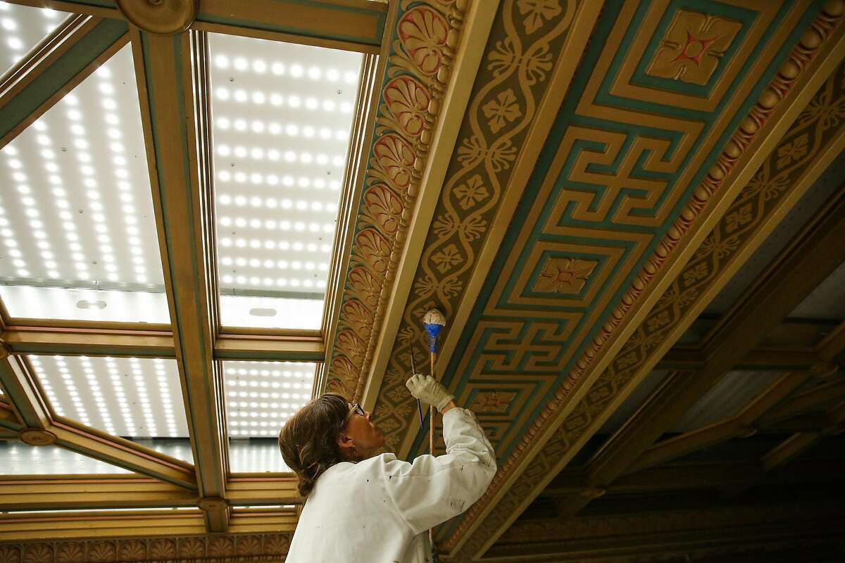 Conservationist Beate Bruhl paints the historic 45-foot high ceiling of the Mining Exchange building in San Francisco.