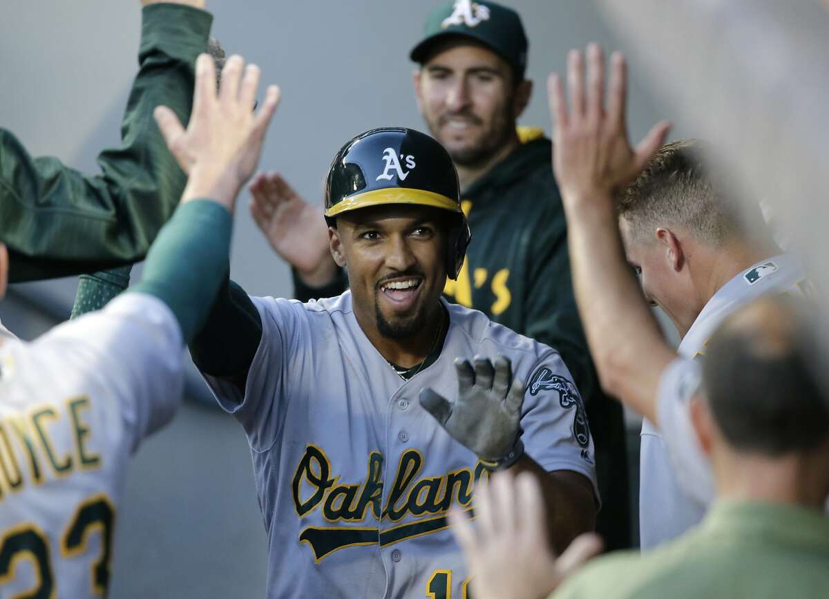 Oakland Athletics' Marcus Semien is congratulated in the dugout after hitting a solo home run off Seattle Mariners' Andrew Moore during the fifth inning of a baseball game, Saturday, July 8, 2017, in Seattle.