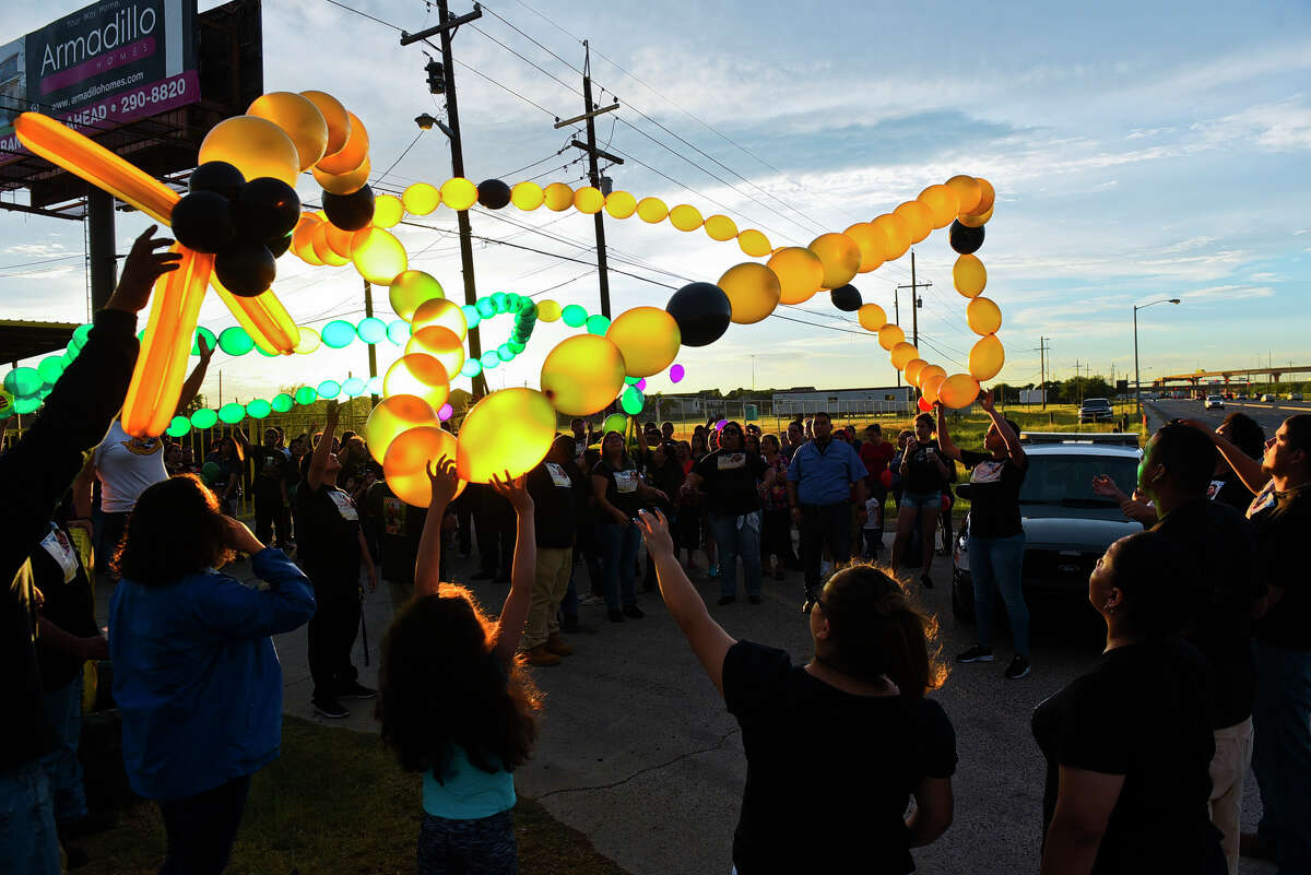 Family and friends of the late David Alejandres and Jorge Salazar Jr. release a set of balloons shaped like a rosary into the sky on Friday on Mines Road during a vigil held for Alejandres and Salazar.